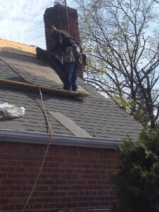 man fixing roof with brick wall