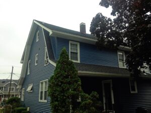 dark blue roof with white trim windows and trees