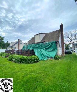 house under construction with green tarp