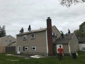 people working on the roof of a large home